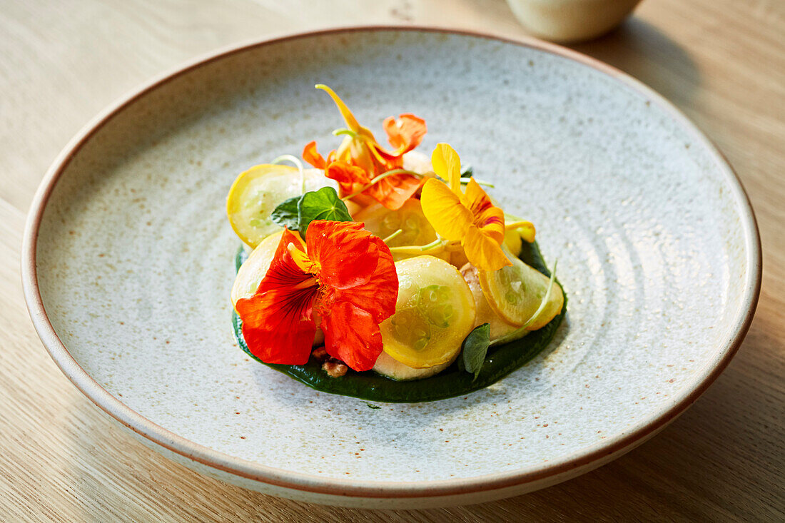 Yellow courgette salad decorated with edible flowers