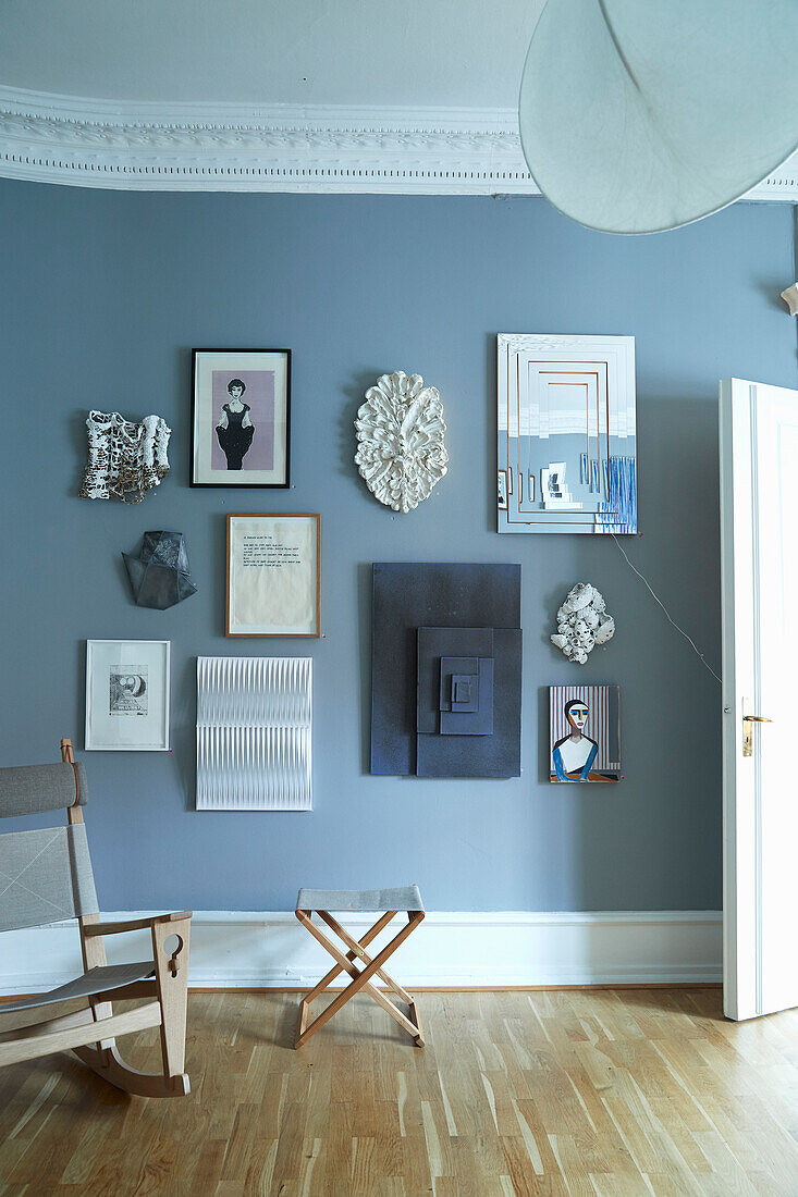 Seating area next to gallery of pictures on blue wall