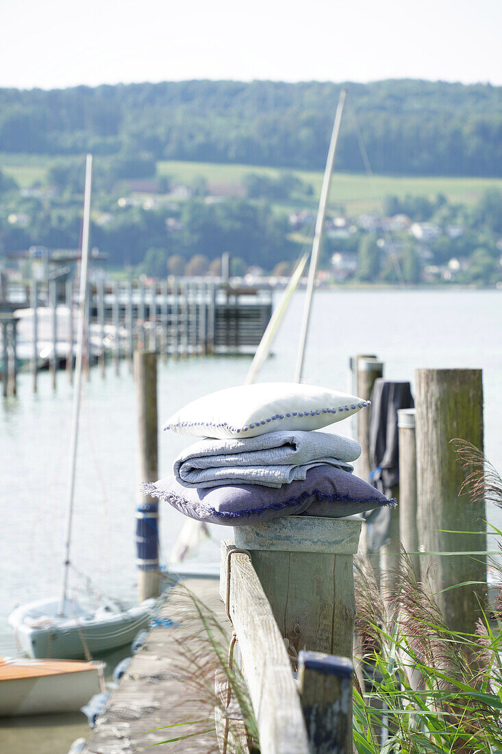 Pile of folded textiles on the jetty with a view of the lake