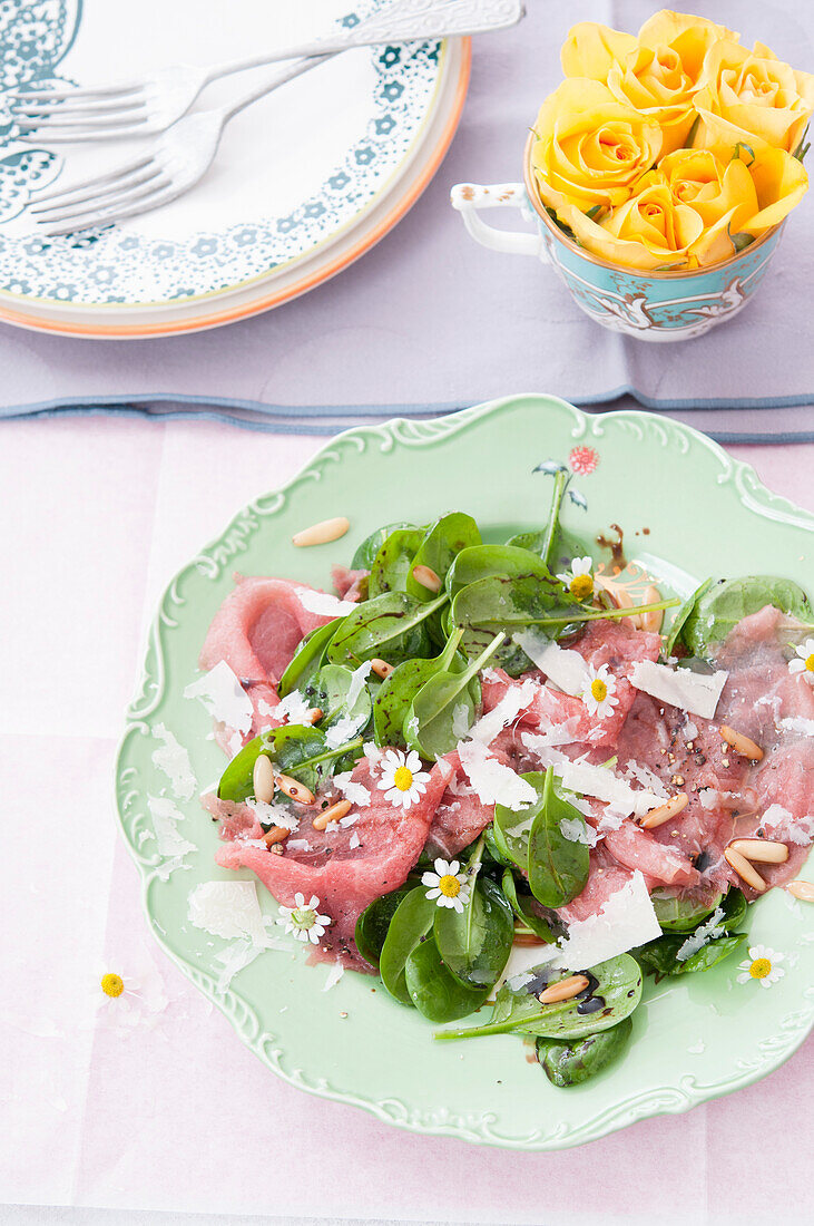 Carpaccio with baby spinach salad and edible flowers