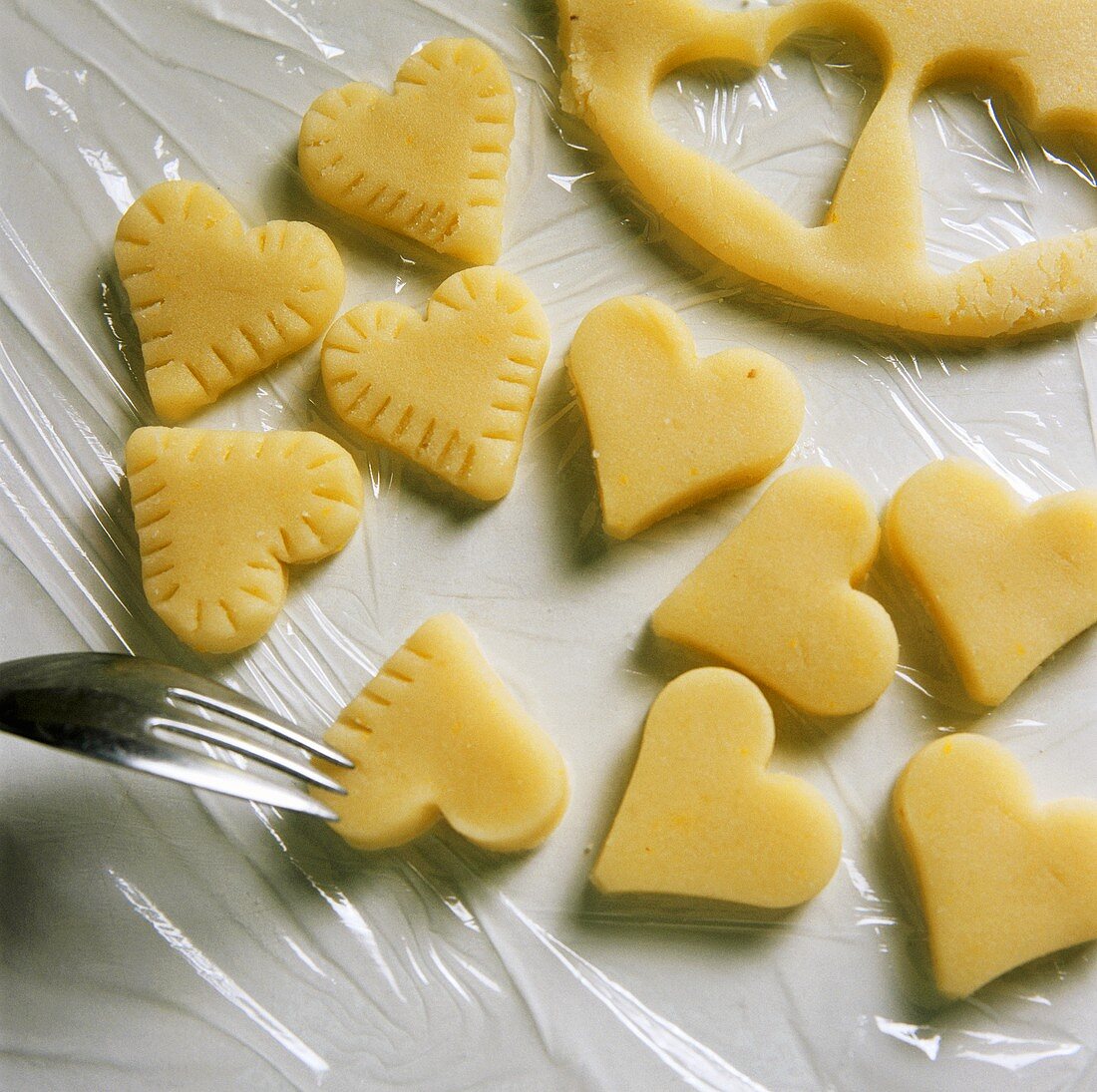 Decorating the edge of marzipan hearts with a fork