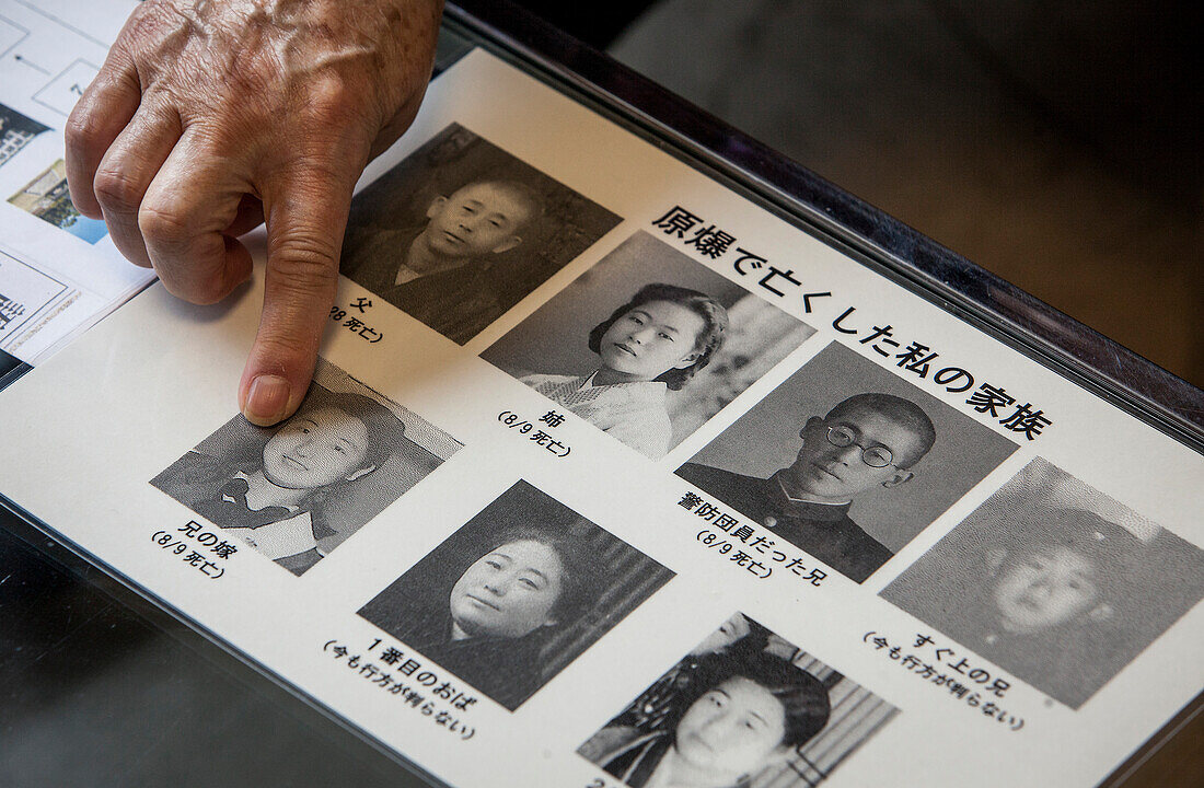 Atomic bomb survivor showing a photo of dead relatives