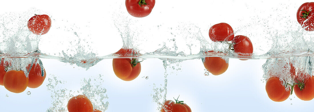 Tomatoes splashing in water