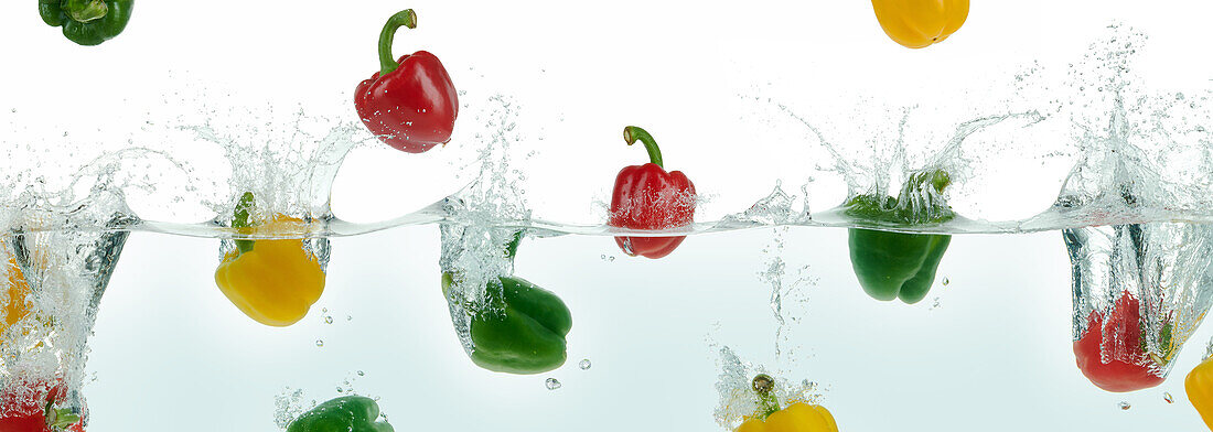 Peppers splashing in water