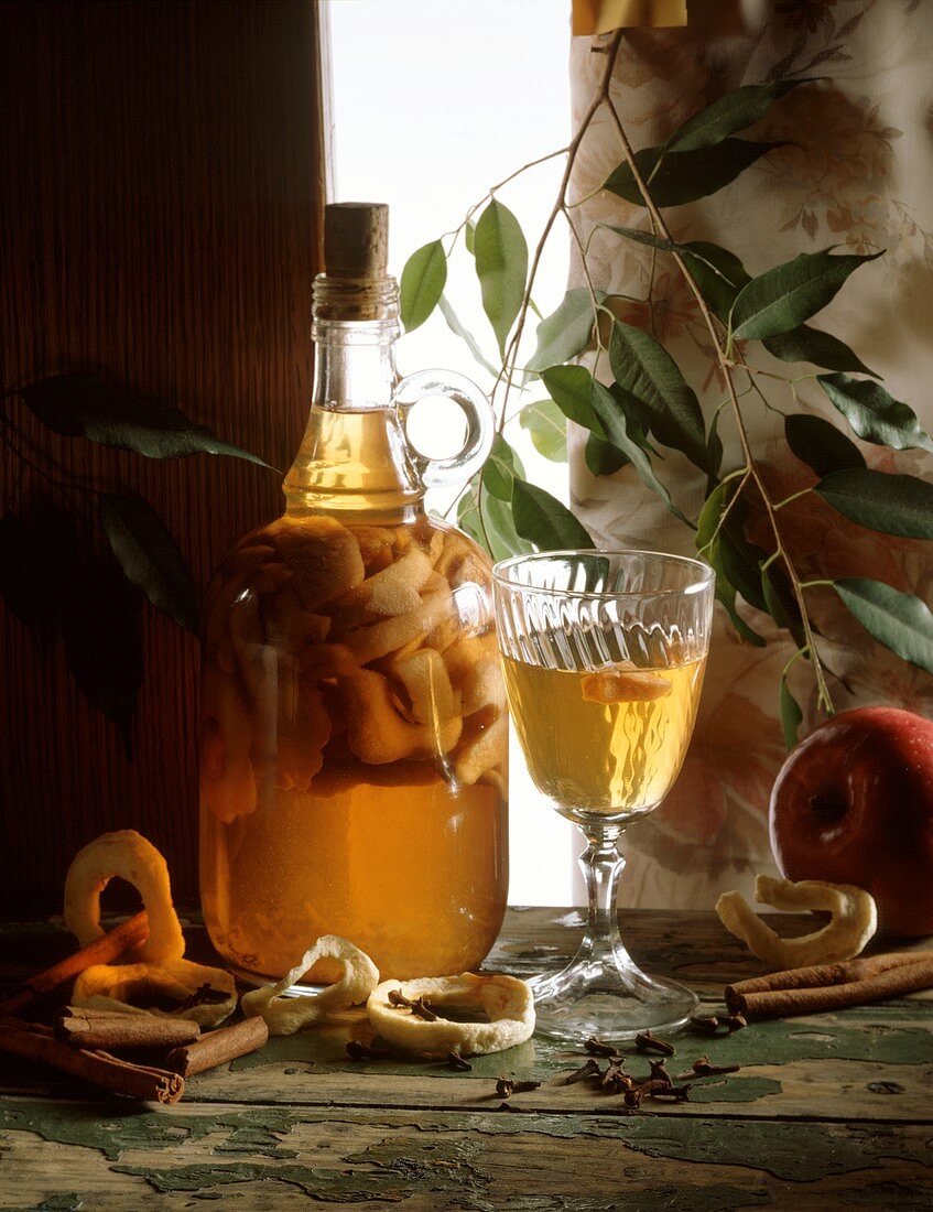 Home-made apple liqueur in glass and carafe