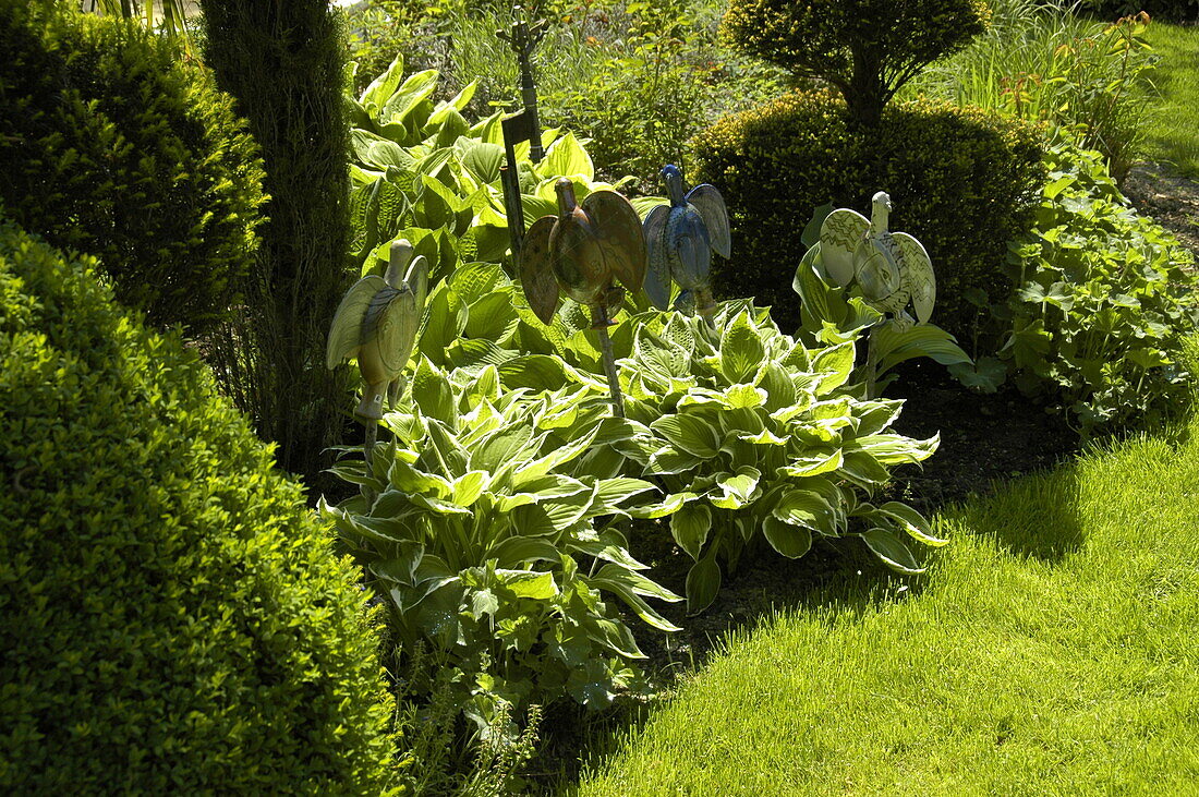 Ceramic animals in the funkia bed