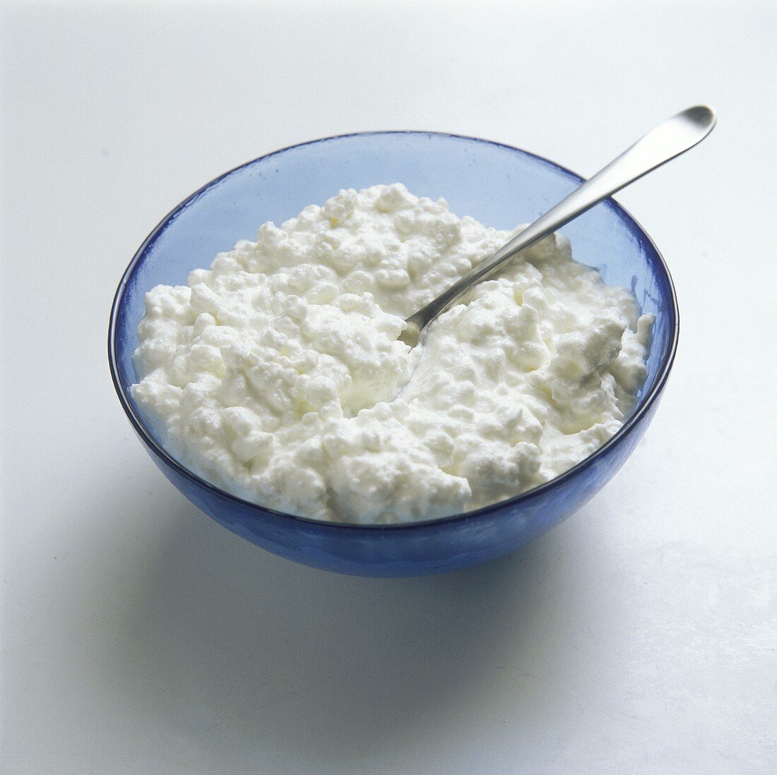 Cottage cheese in a blue bowl with spoon