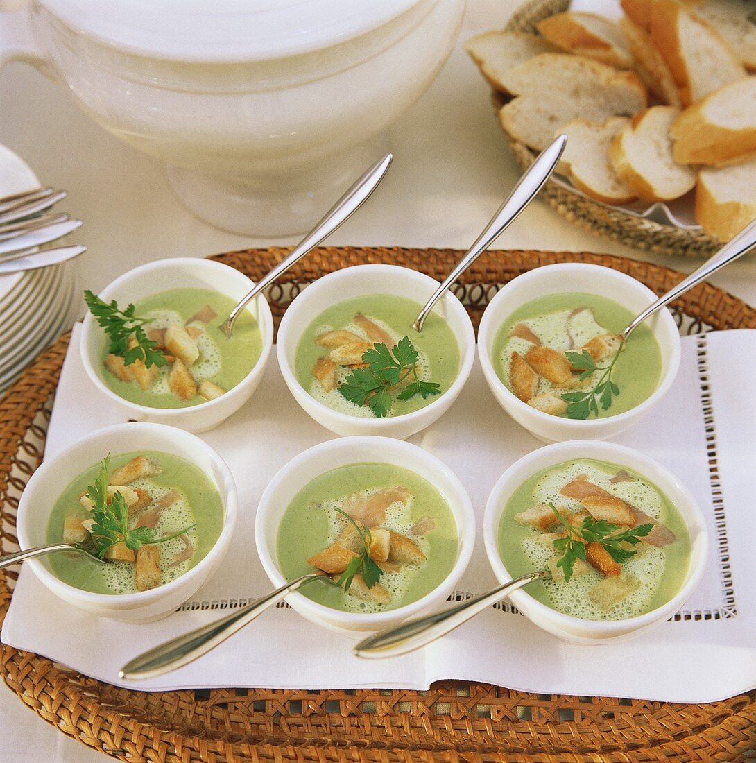 Pea soup with salmon strips and croutons in bowl