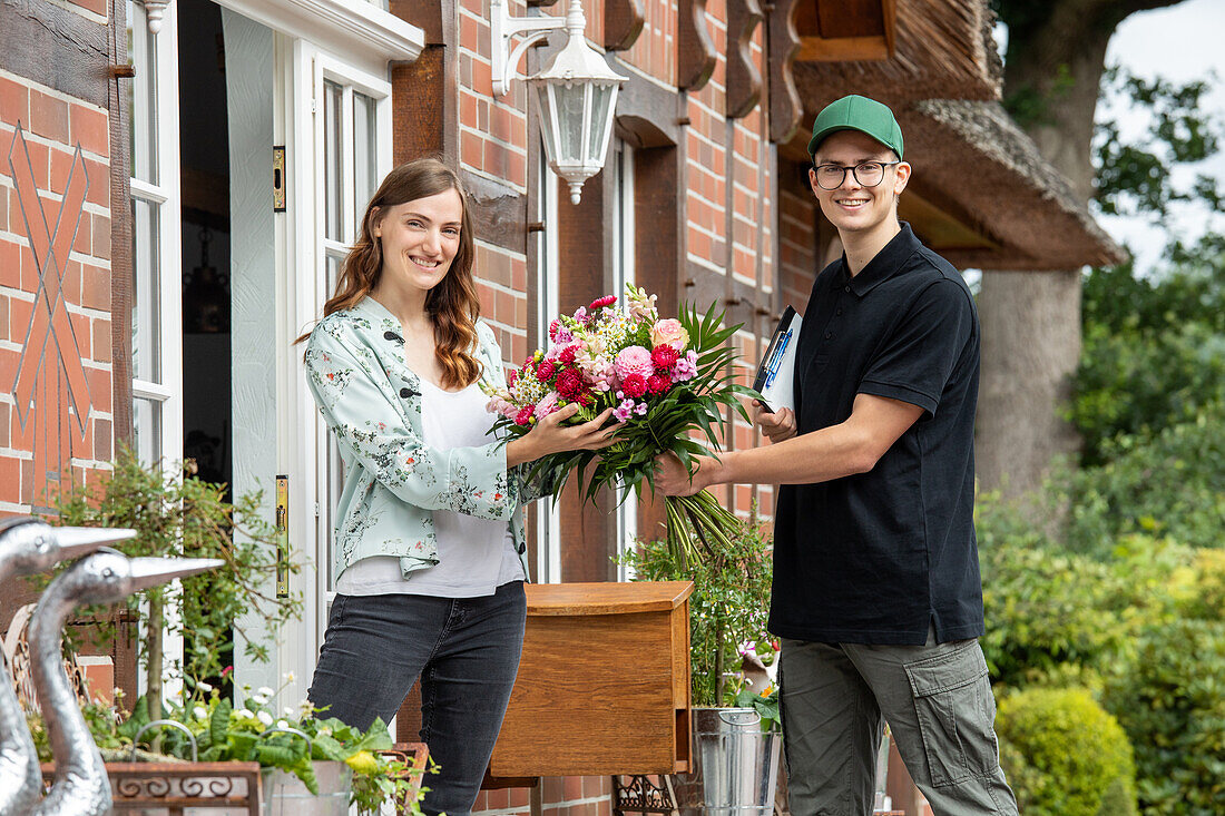 Delivery service - supplier hands over bouquet of flowers