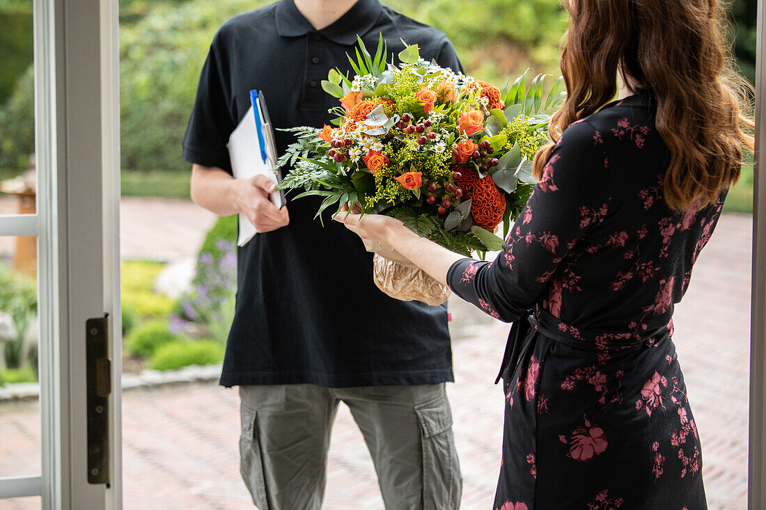 Delivery service - supplier hands over bouquet of flowers