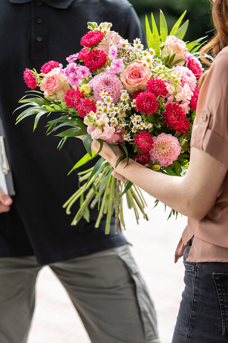 Lieferservice - Lieferant übergibt Blumenstrauß