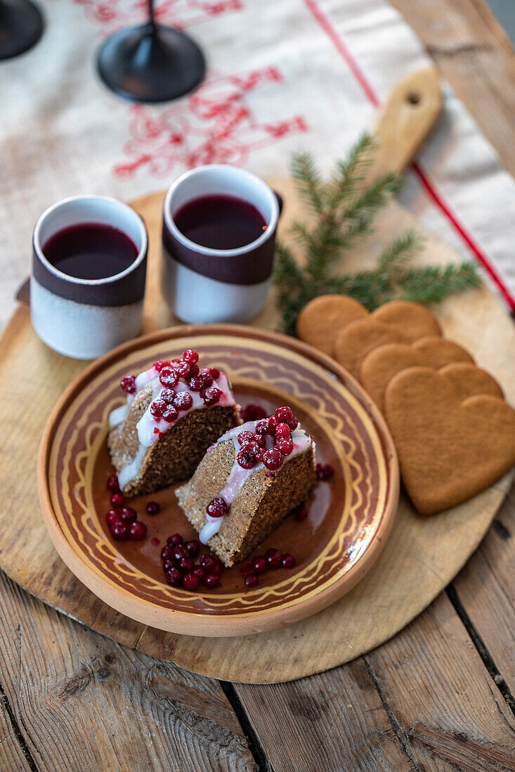 Christmas cake with cranberries and mulled wine on a rustic wooden table