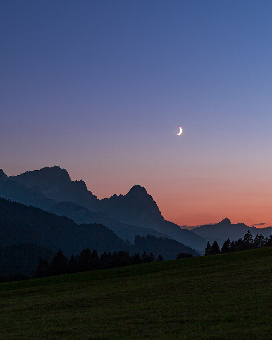 Crescent Moon and Earthshine over mountains, Bavaria