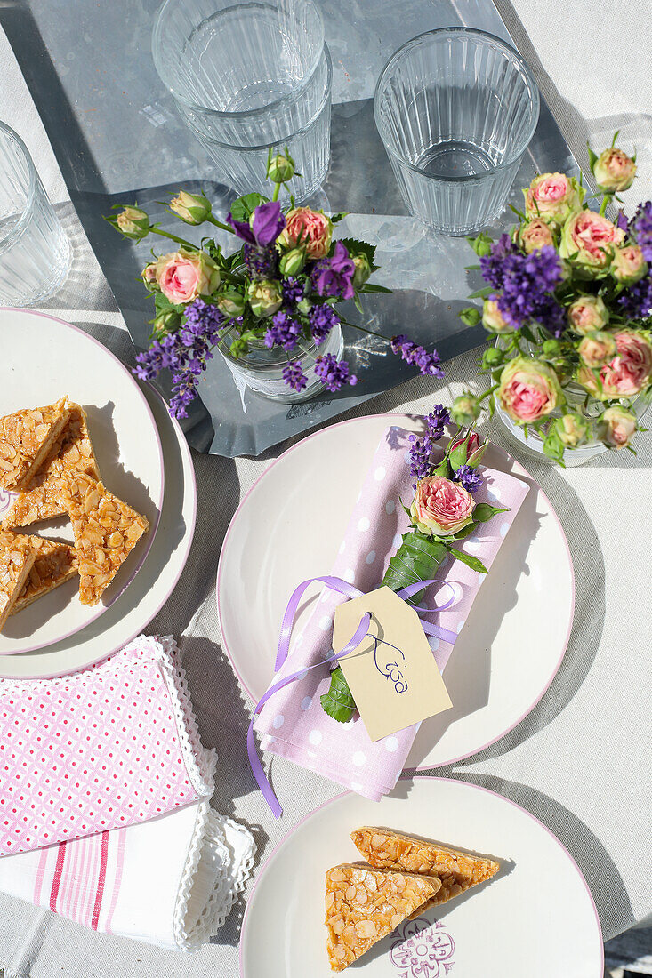 Spring table decoration with bouquets of flowers and almond slices