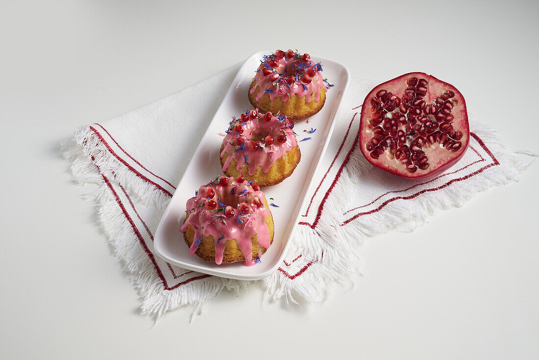 Glazed mini cakes with pomegranate seeds