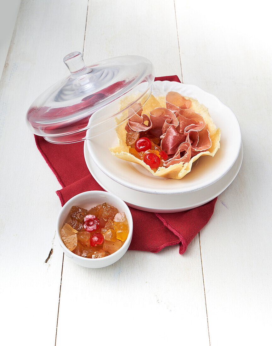 Parmesan basket with raw ham and mustard fruits