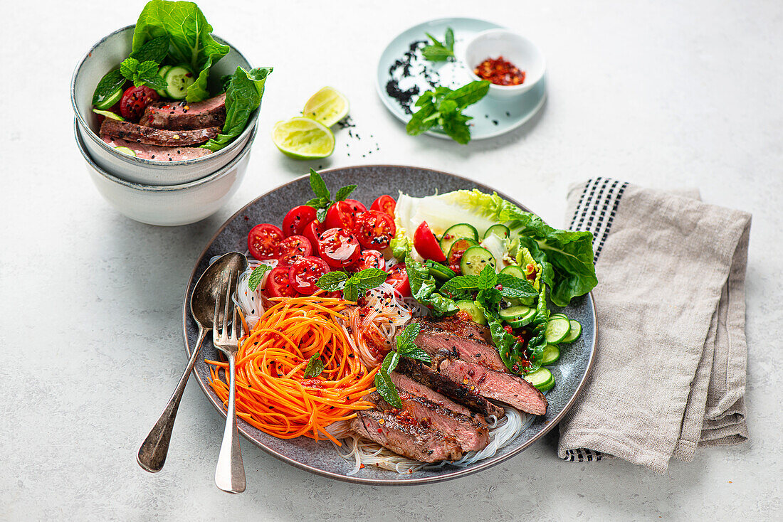 Rice noodle and vegetable bowl with beef steak