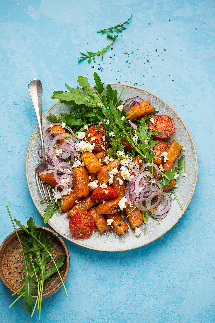 Süßkartoffel-Gnocchisalat mit Feta, Rucola und roten Zwiebeln