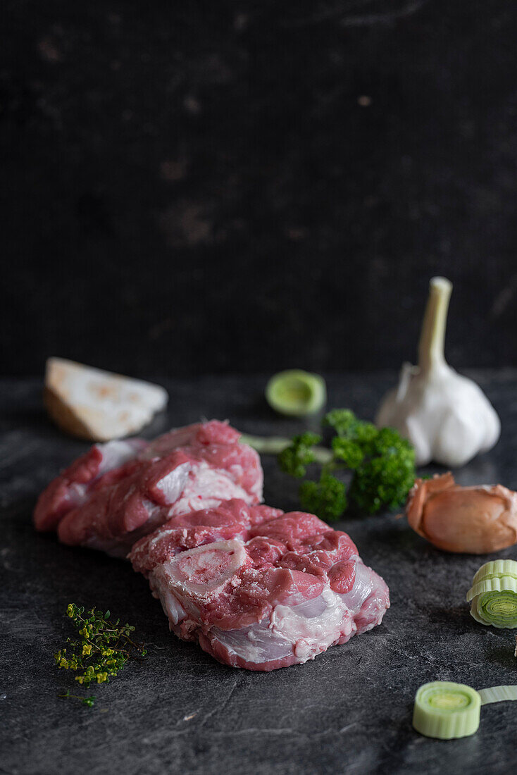 Raw veal leg slices for ossobuco and ingredients