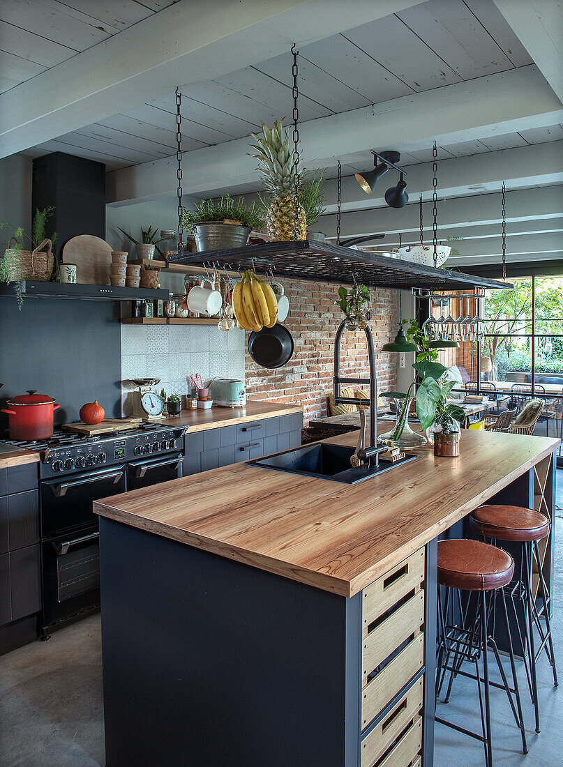 Modern kitchen with wooden beamed ceiling and wooden island