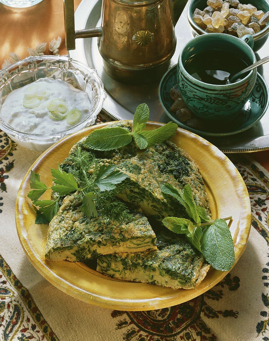 Arabian herb omelette on plate & yoghurt sauce in bowl