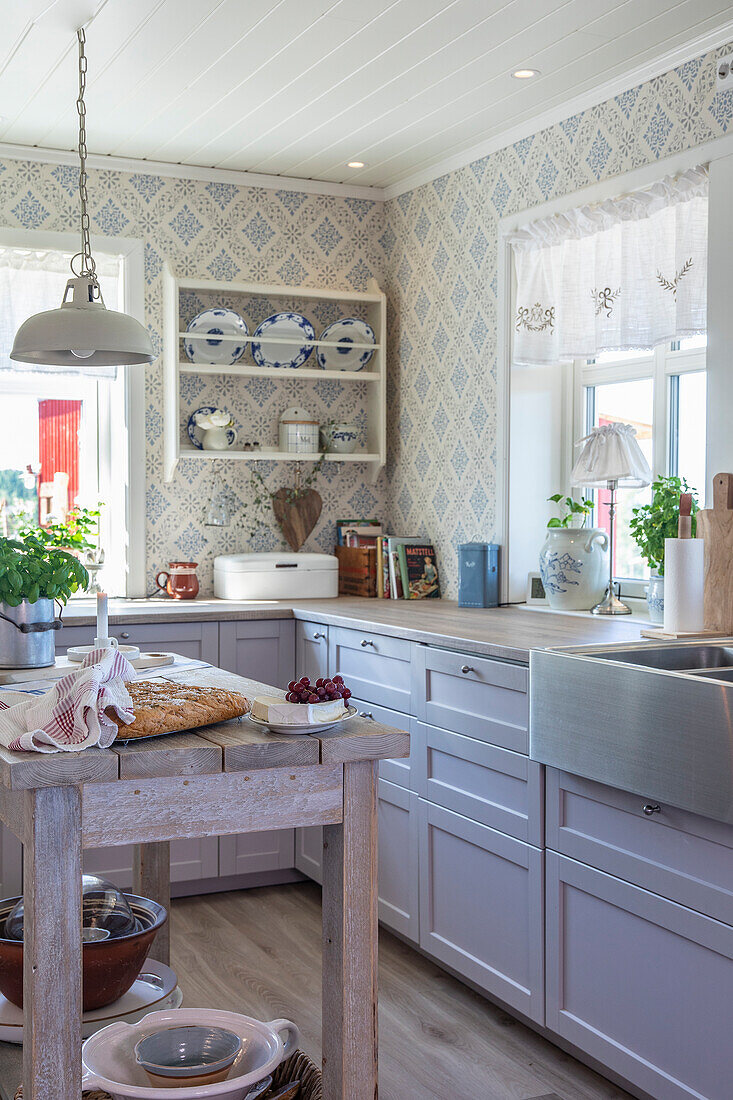 Country kitchen with blue-patterned wallpaper