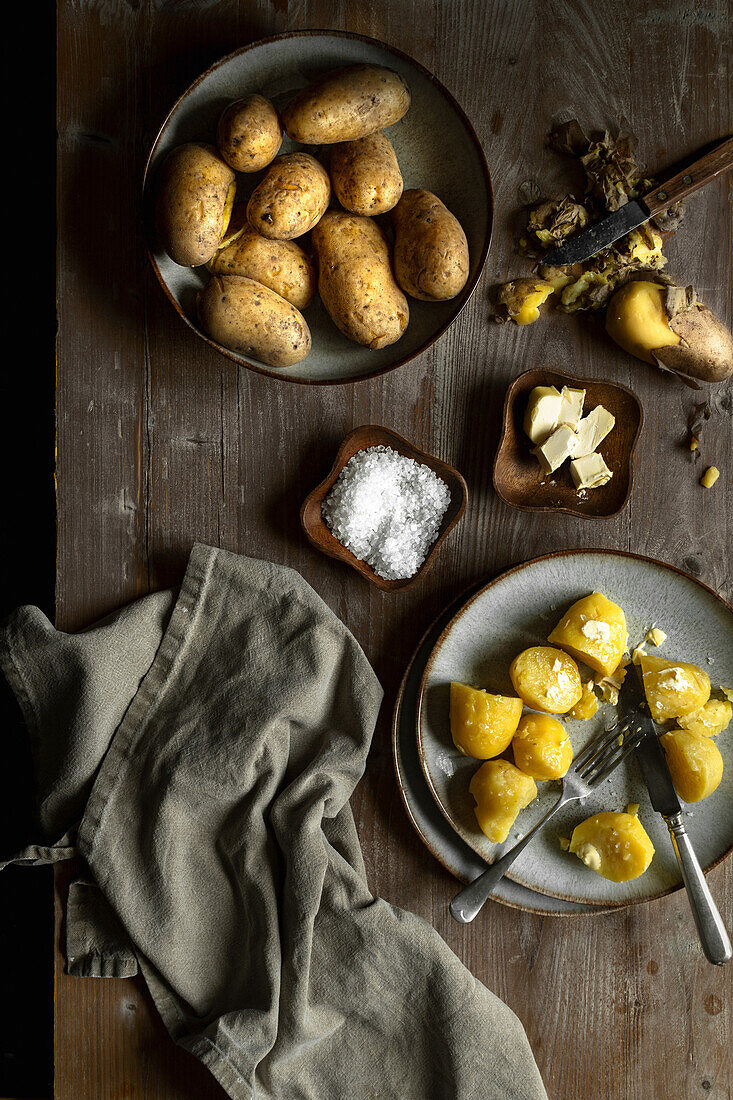 Gekochte Kartoffeln mit und ohne Schale, serviert mit Butter und Salz