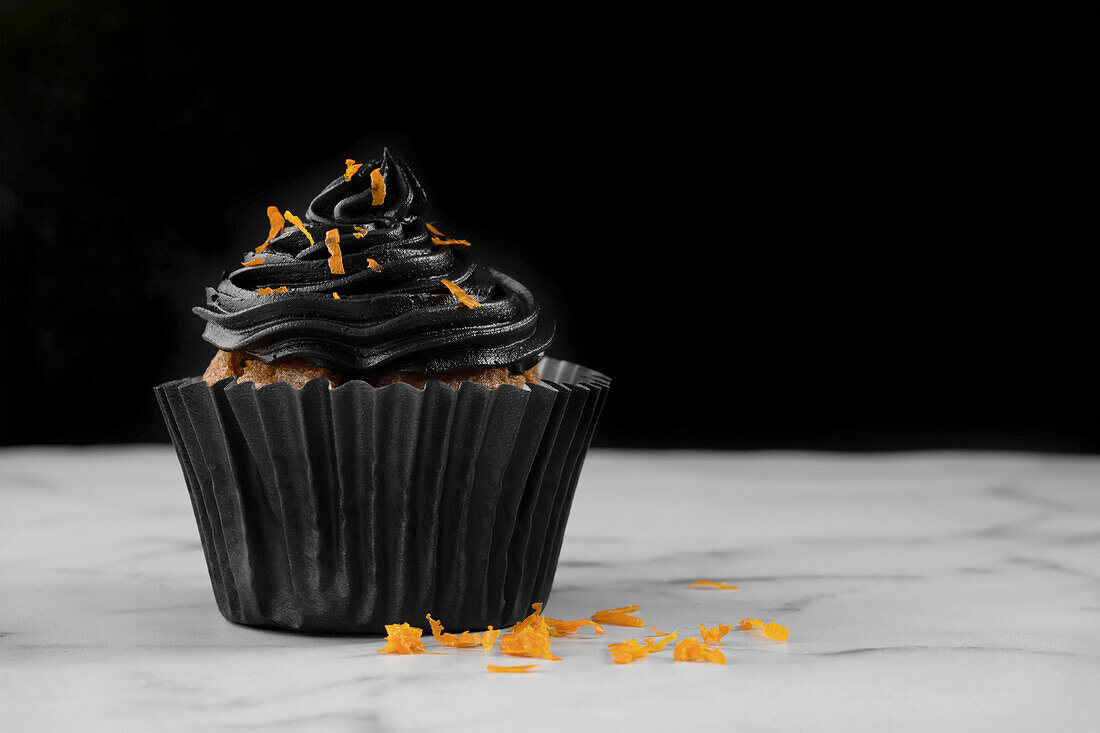 Halloween cupcake with black buttercream and orange zest