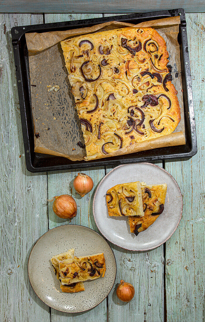 Onion focaccia on tray and pieces on plates