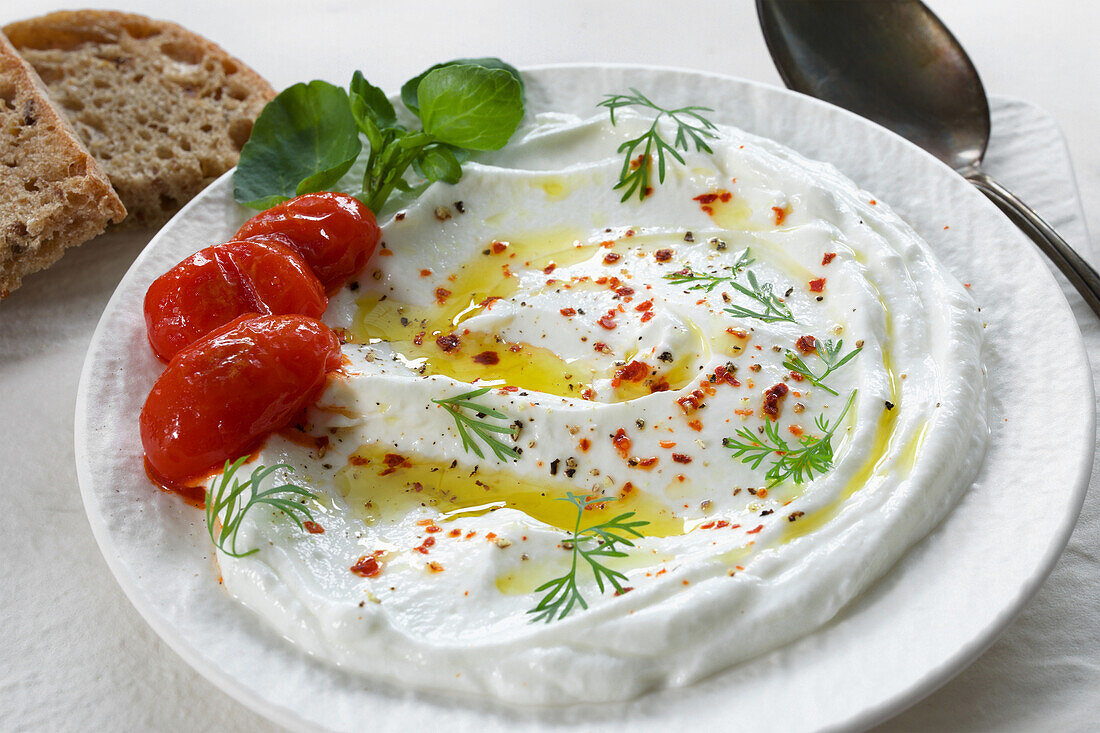 Labneh garnished with roasted tomatoes, olive oil and Aleppo pepper