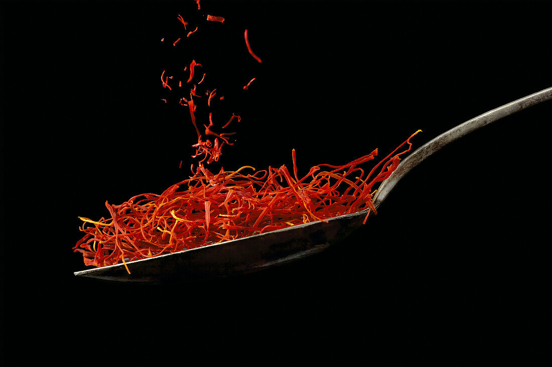 Close-up of saffron falling onto a spoon