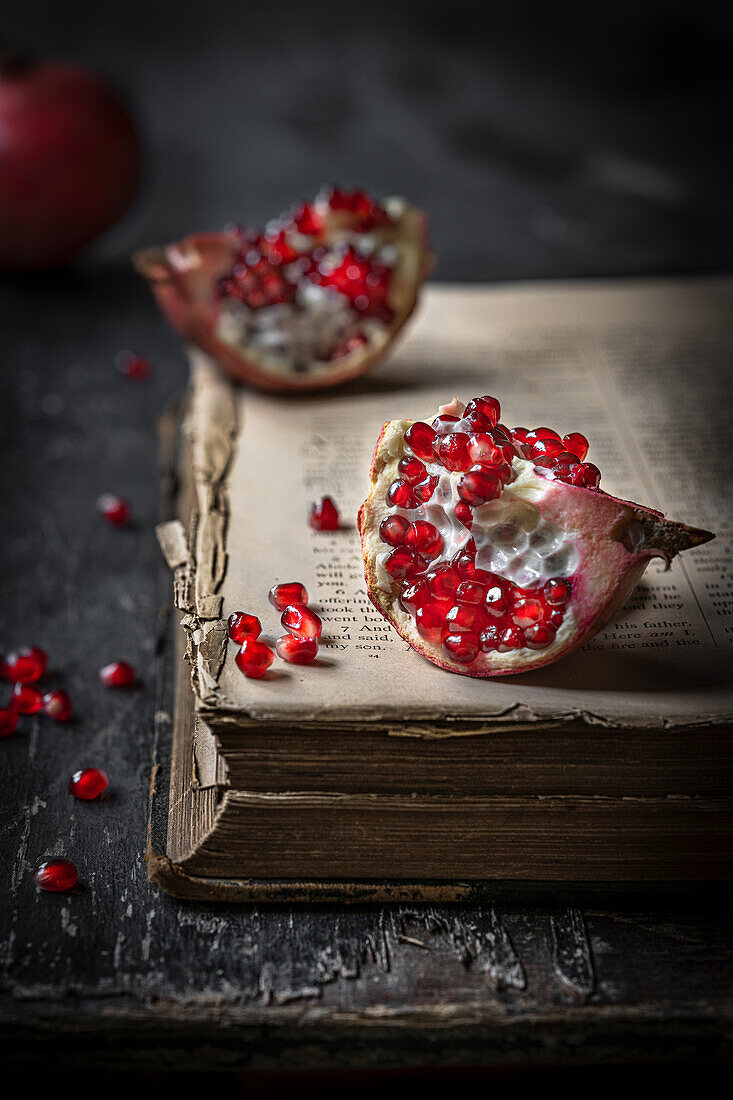 Granatapfel-Stücke auf altem Buch