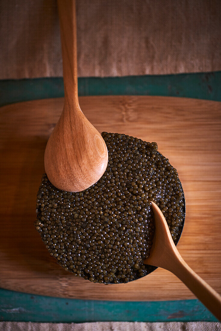 Caviar in a tin with wooden spoons