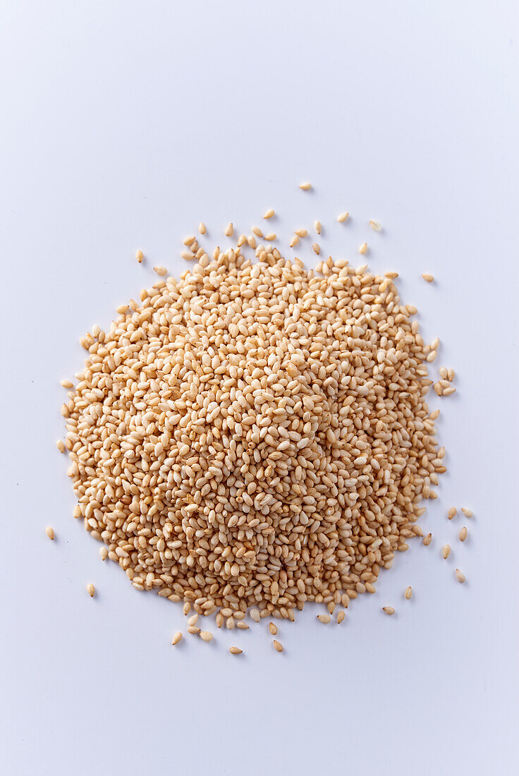 A heap of sesame seeds on a white surface