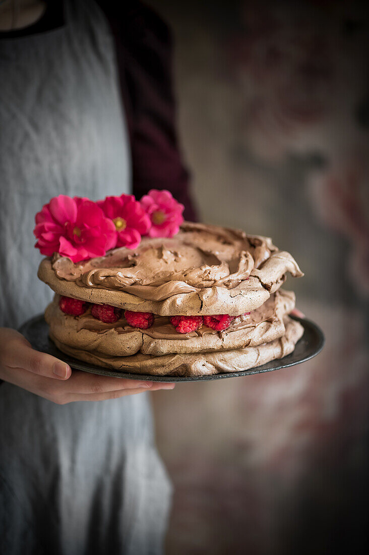 Chocolate meringue cake with chocolate cream and raspberries
