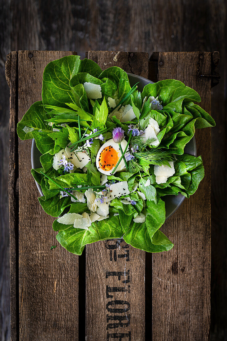 Green salad with parmesan, egg and edible flowers