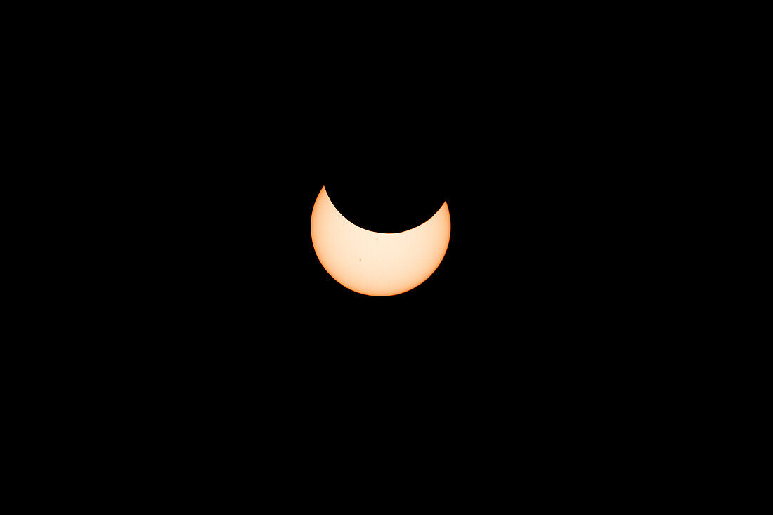 The moon moves in front of the sun during the annular solar eclipse on 14 November 2023. Utah, USA. 36 minutes before annularity.