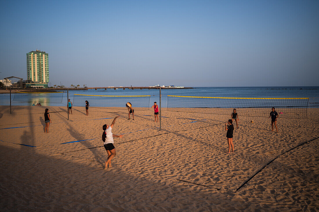 Kids playing volleyball on Arrecife beach in capital city of Lanzarote, Canary Islands, Spain