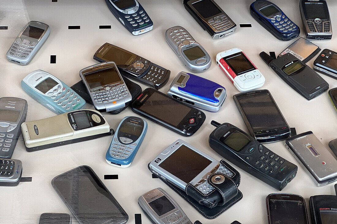 Assorted old celular phones in display window