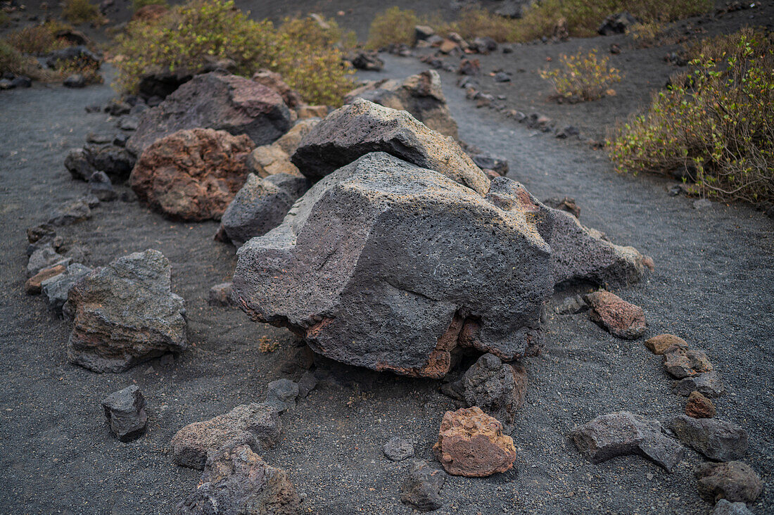 Volcan del Cuervo (Krähenvulkan), ein Krater, der über einen Rundweg in einer kargen, felsigen Landschaft erkundet wird