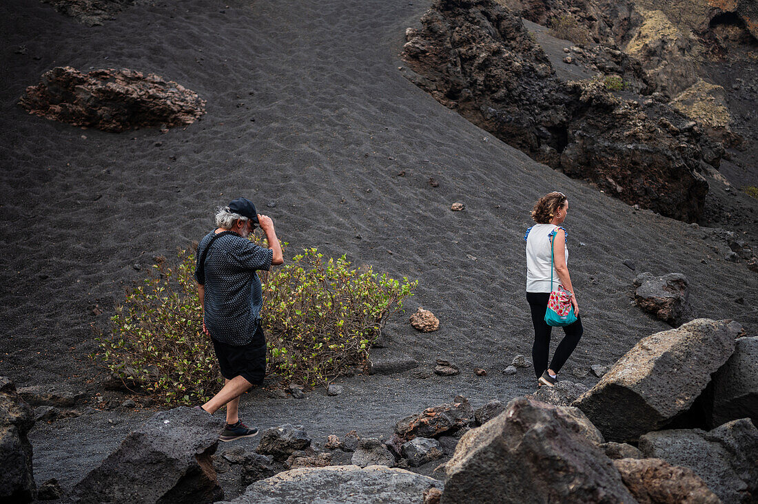 Volcan del Cuervo (Krähenvulkan), ein Krater, der über einen Rundweg in einer kargen, felsigen Landschaft erkundet wird