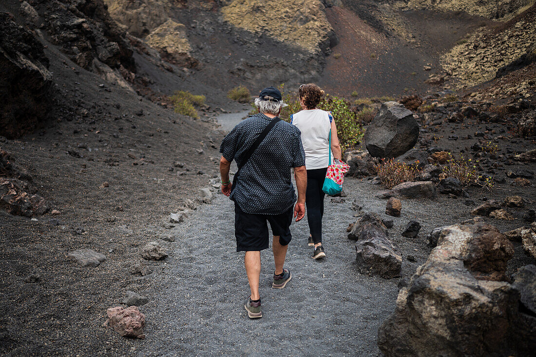 Volcan del Cuervo (Krähenvulkan), ein Krater, der über einen Rundweg in einer kargen, felsigen Landschaft erkundet wird