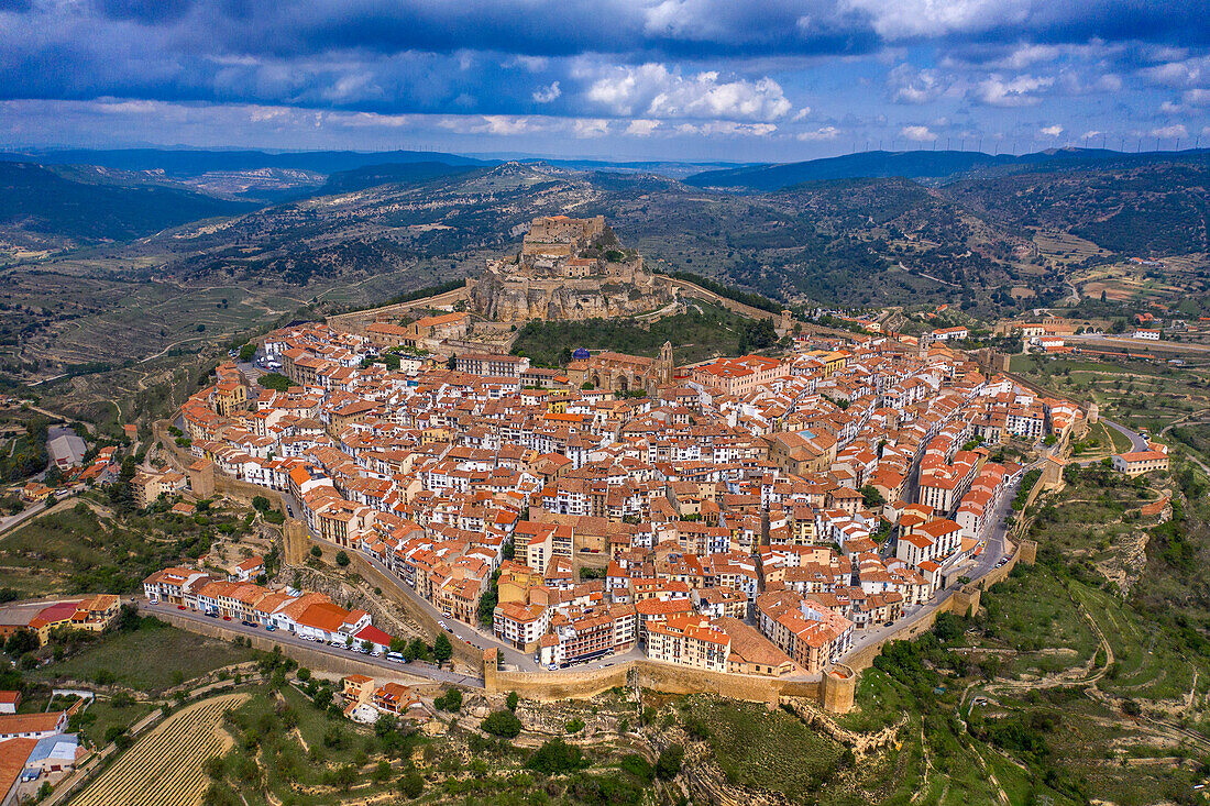 Aerial sunset view of Morella, medieval walled town with semi circular towers and gate houses crowed by a fortress on the rock in Spain, Valencia comunity, Castellon province.