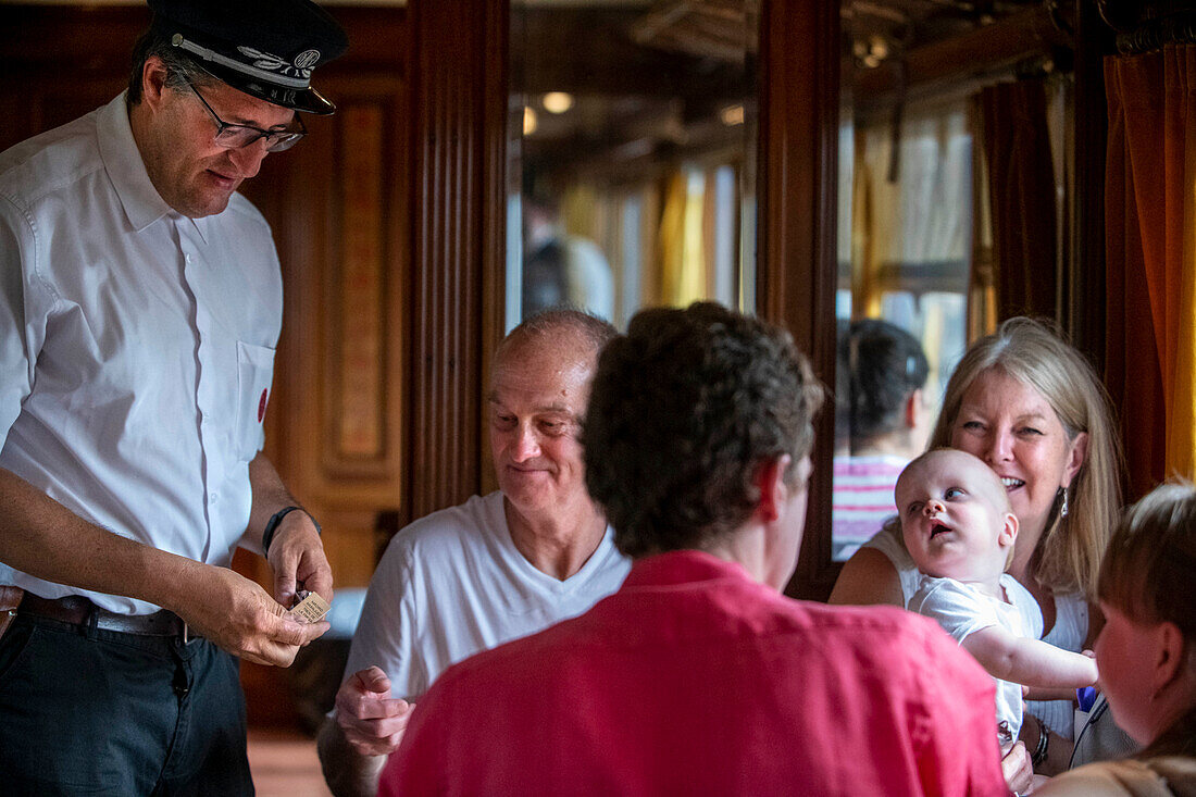 Inspector and passengers inside the Strawberry train that goes from Madrid Delicias train station to Aranjuez city Madrid, Spain.