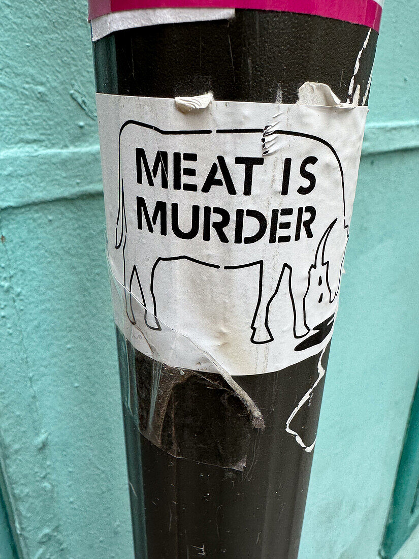 Meat is murder sticker on street sign