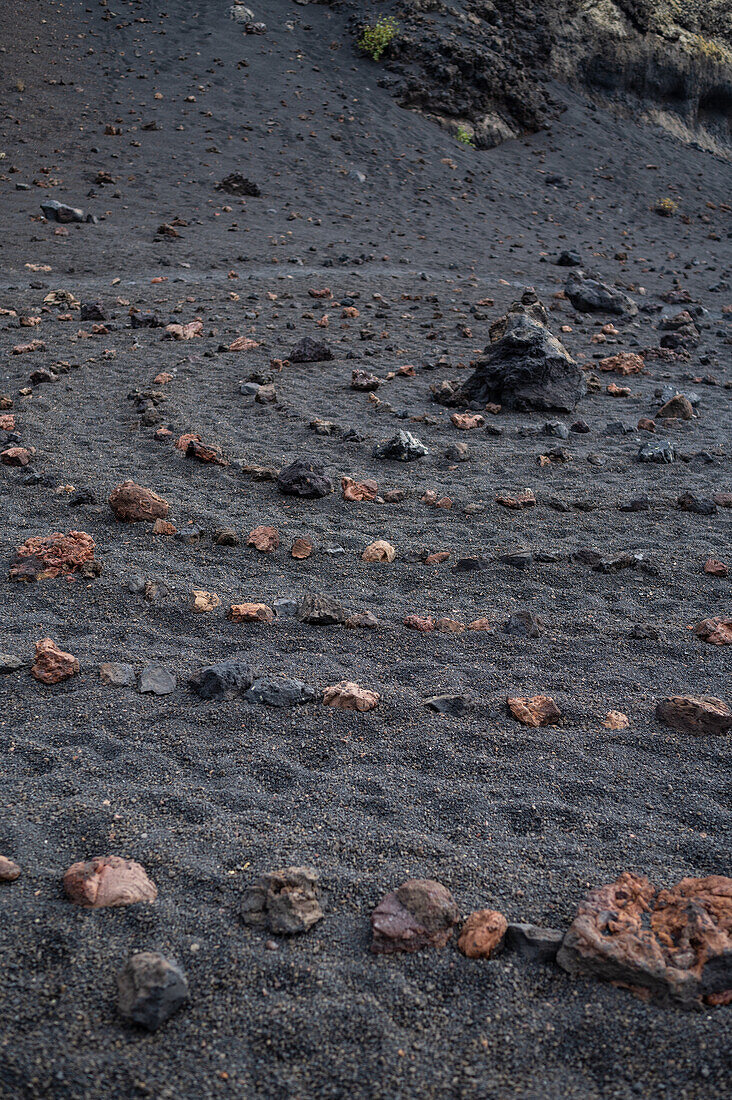 Volcan del Cuervo (Krähenvulkan), ein Krater, der auf einem Rundweg in einer kargen, felsdurchsetzten Landschaft erkundet wird