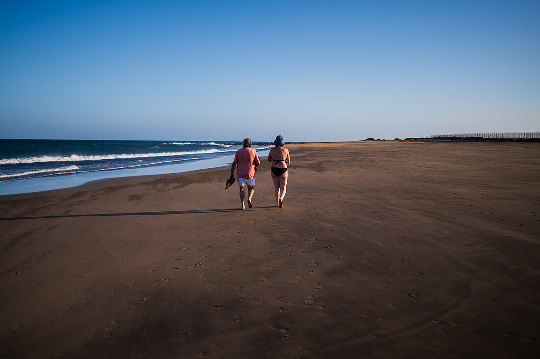 Couple walks on the beach in Lanzarote, Canary Islands, Spain