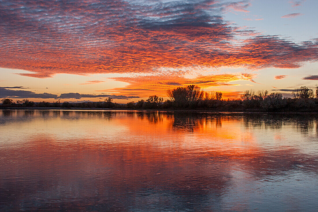 Farbenfroher Himmel bei Sonnenuntergang, der sich im Green River bei Jensen, Utah, spiegelt