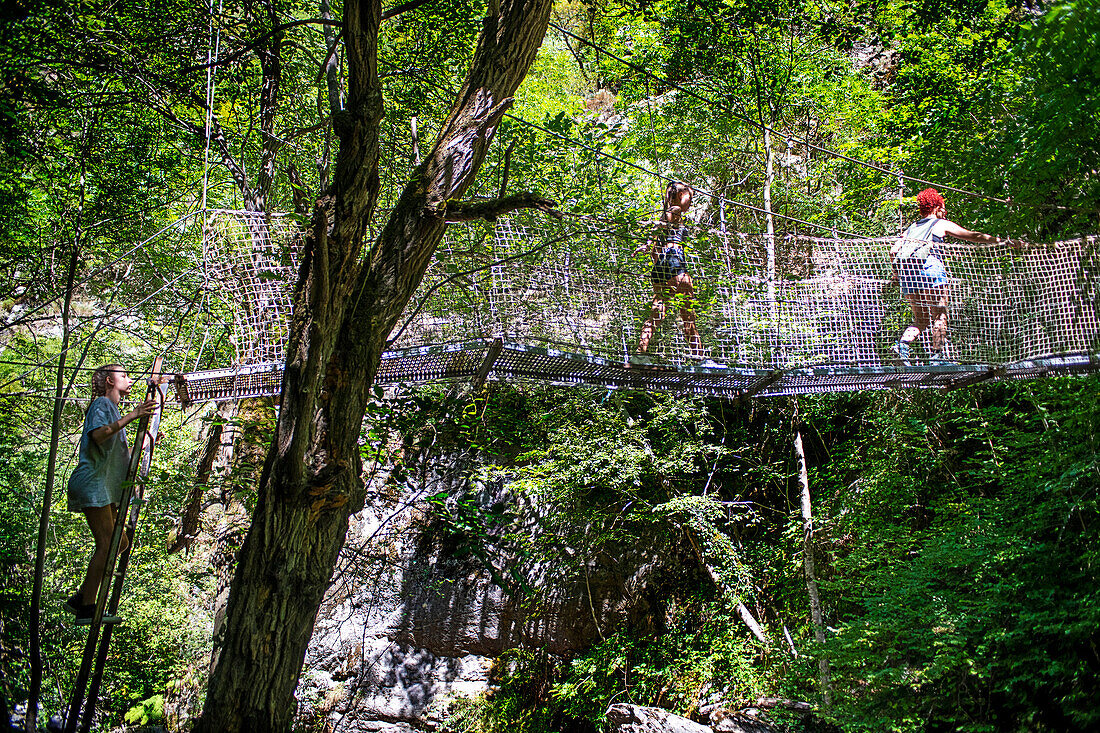 Wanderer überquert eine Hängebrücke aus Metall auf dem Wanderweg durch die Carança-Schlucht, Pyrénées-Orientales, Languedoc-Roussillon, Frankreich