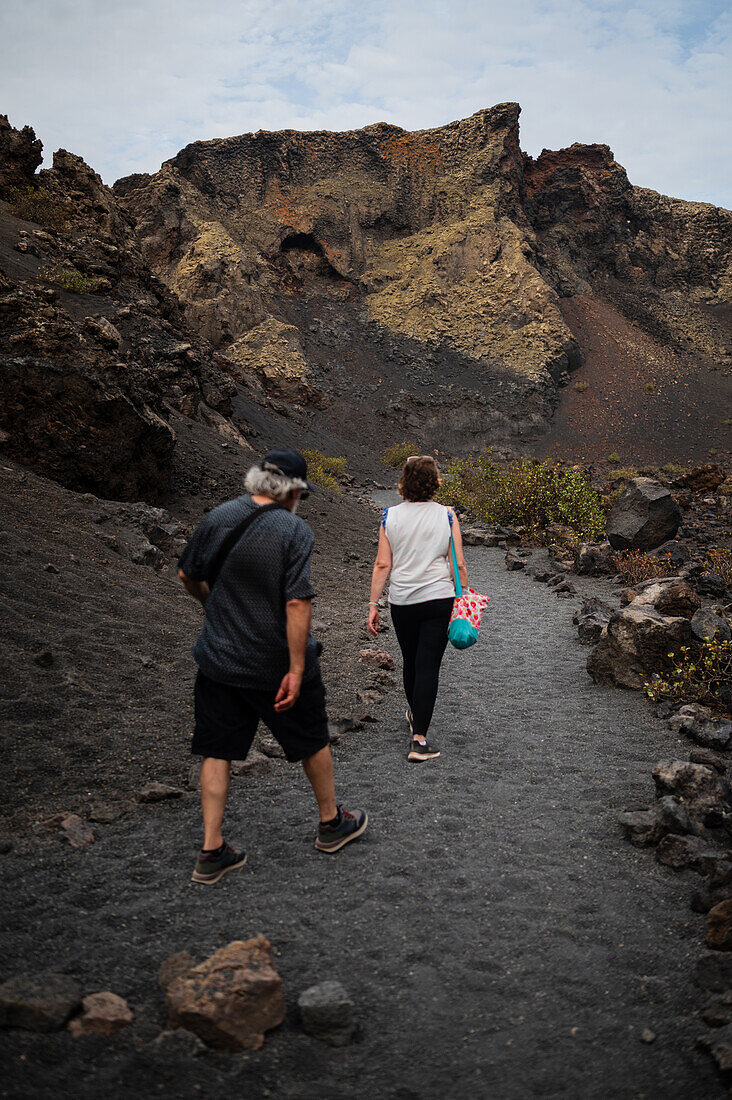 Volcan del Cuervo (Krähenvulkan), ein Krater, der auf einem Rundweg in einer kargen, von Felsen übersäten Landschaft erkundet wird